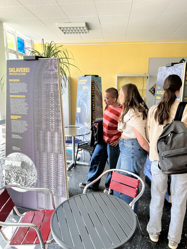 Zu sehen sind Schülerinnen, während sie Texte der Ausstellung lesen