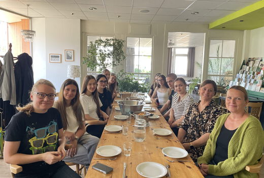 Gruppe von Menschen an einem Tisch, gedeckt für ein großes gemeinsaes Essen